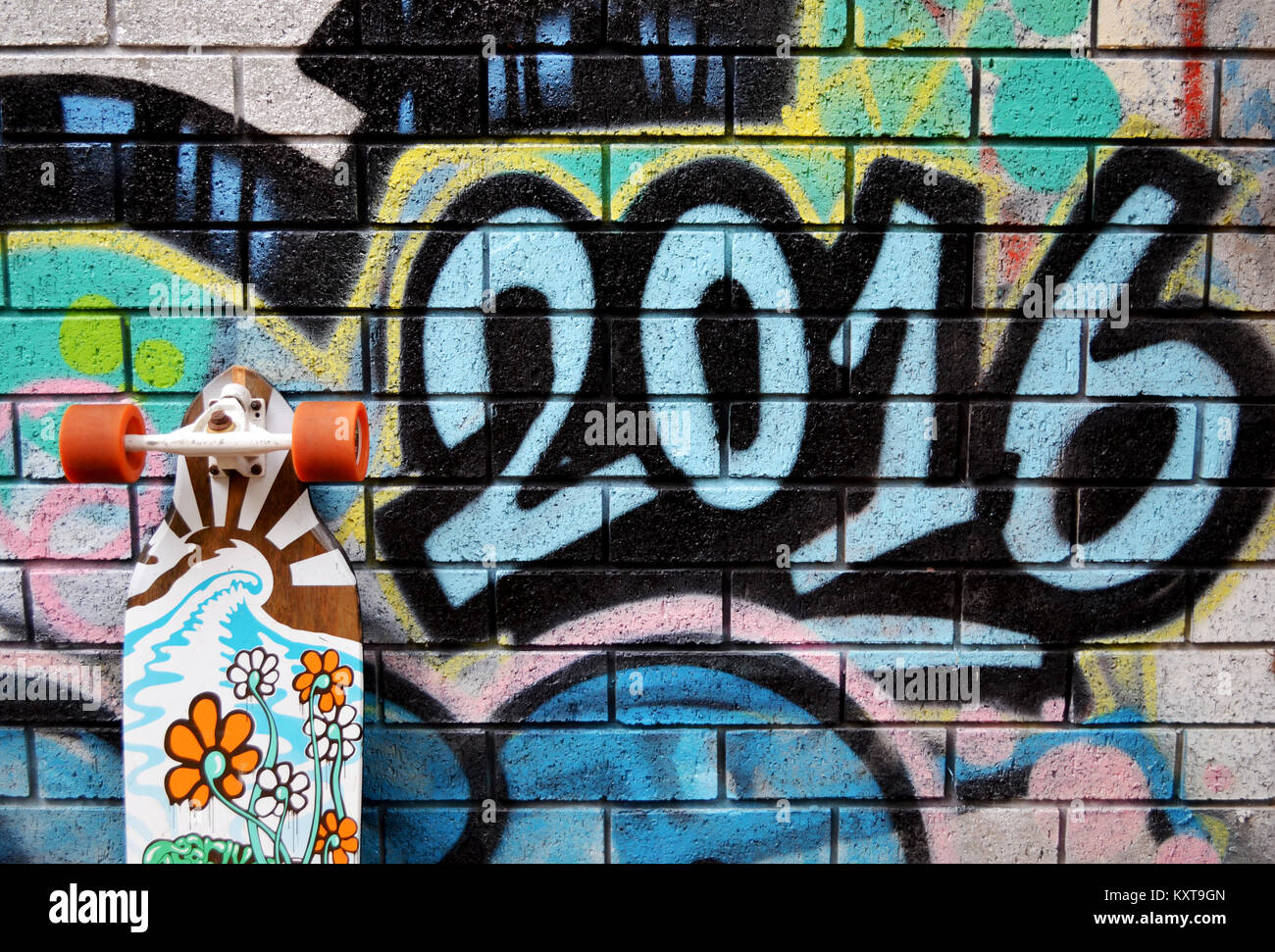Longboard skateboard leaning against wall with graffiti Stock Photo Alamy