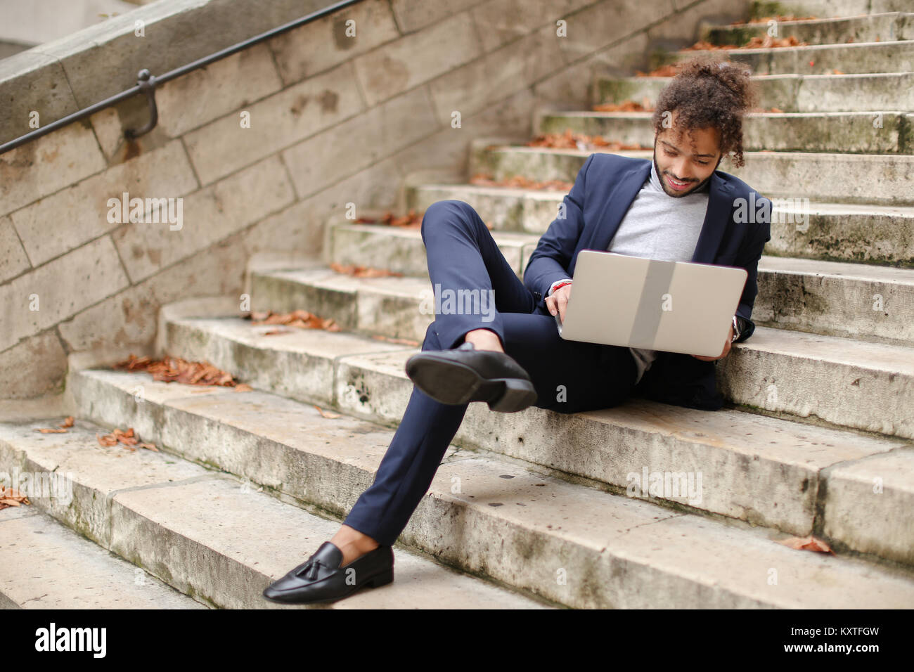 Personnel consultant chatting with client by laptop on steps. Stock Photo