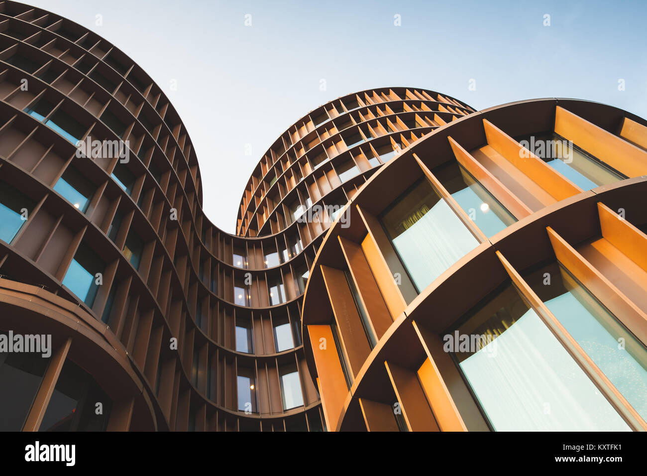 Abstract contemporary architecture background, round towers made of yellow shiny metal and glass Stock Photo