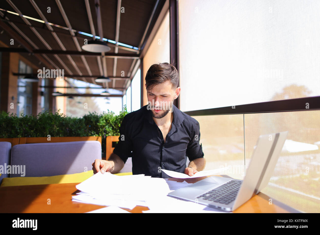 Office worker sorting papers on table near laptop Stock Photo - Alamy
