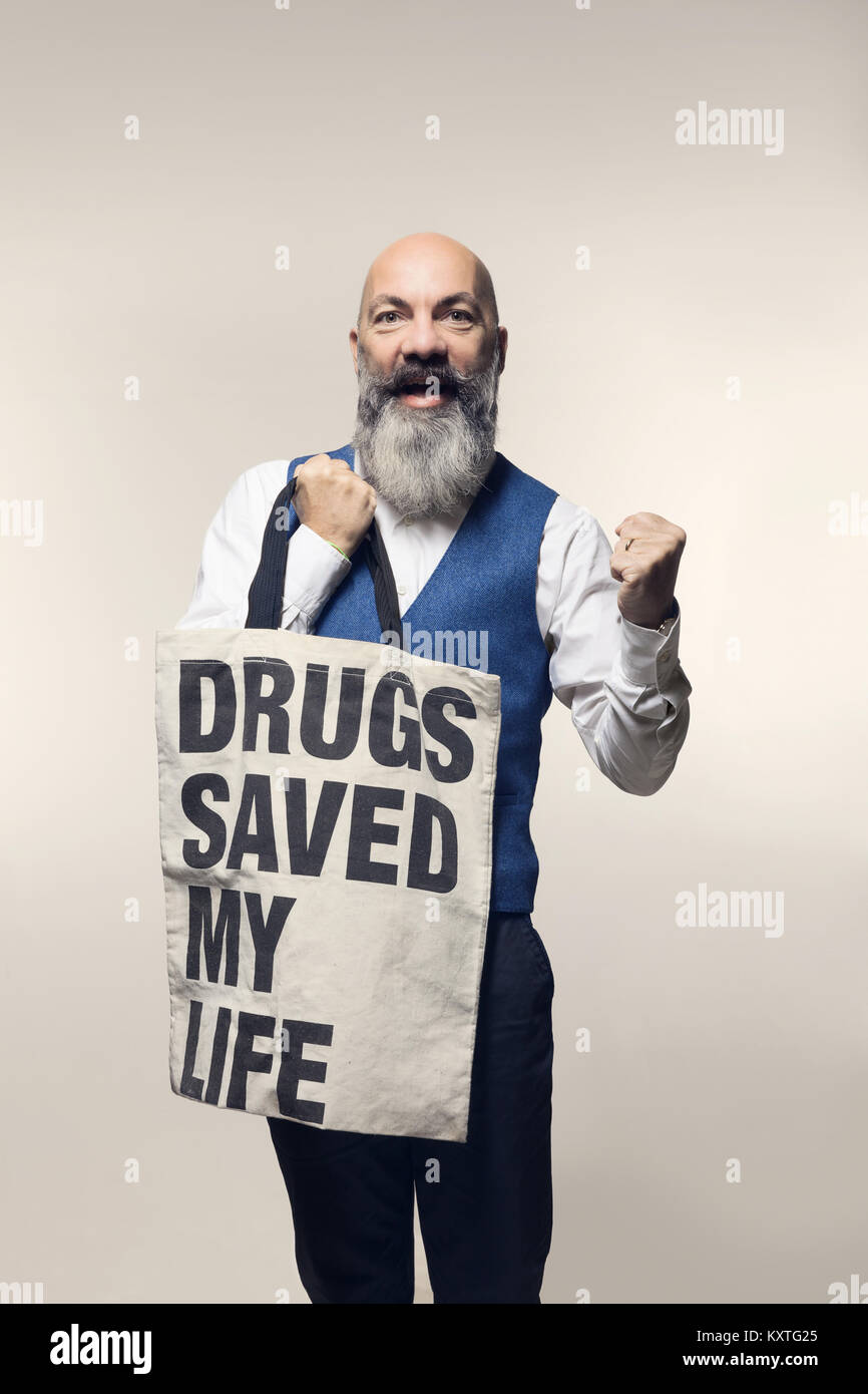 Man shows a bag with slogan, studio portrait. Drugs saved my life Stock Photo