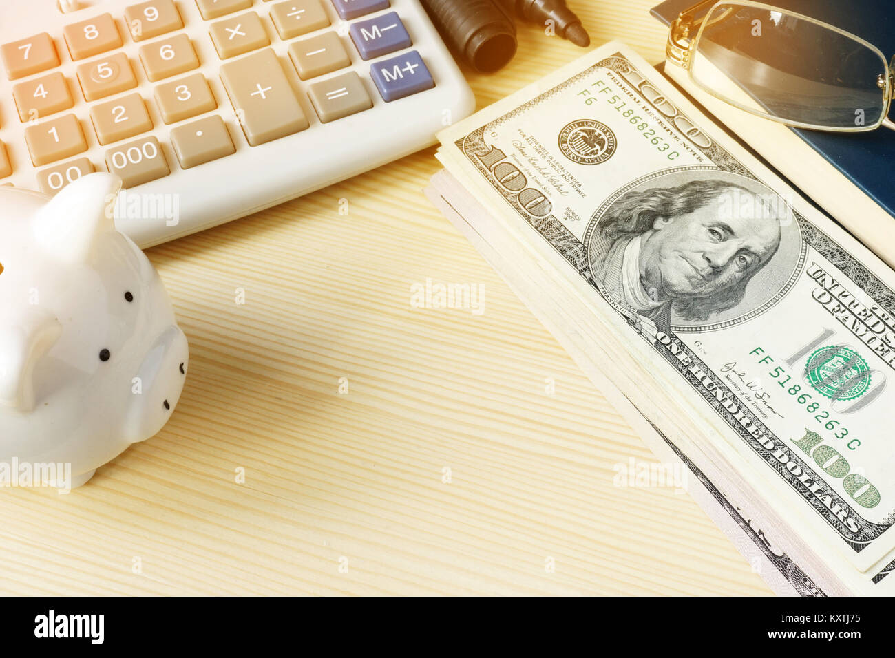 Office desk with money, piggy bank and accounting book. Small business concept. Stock Photo