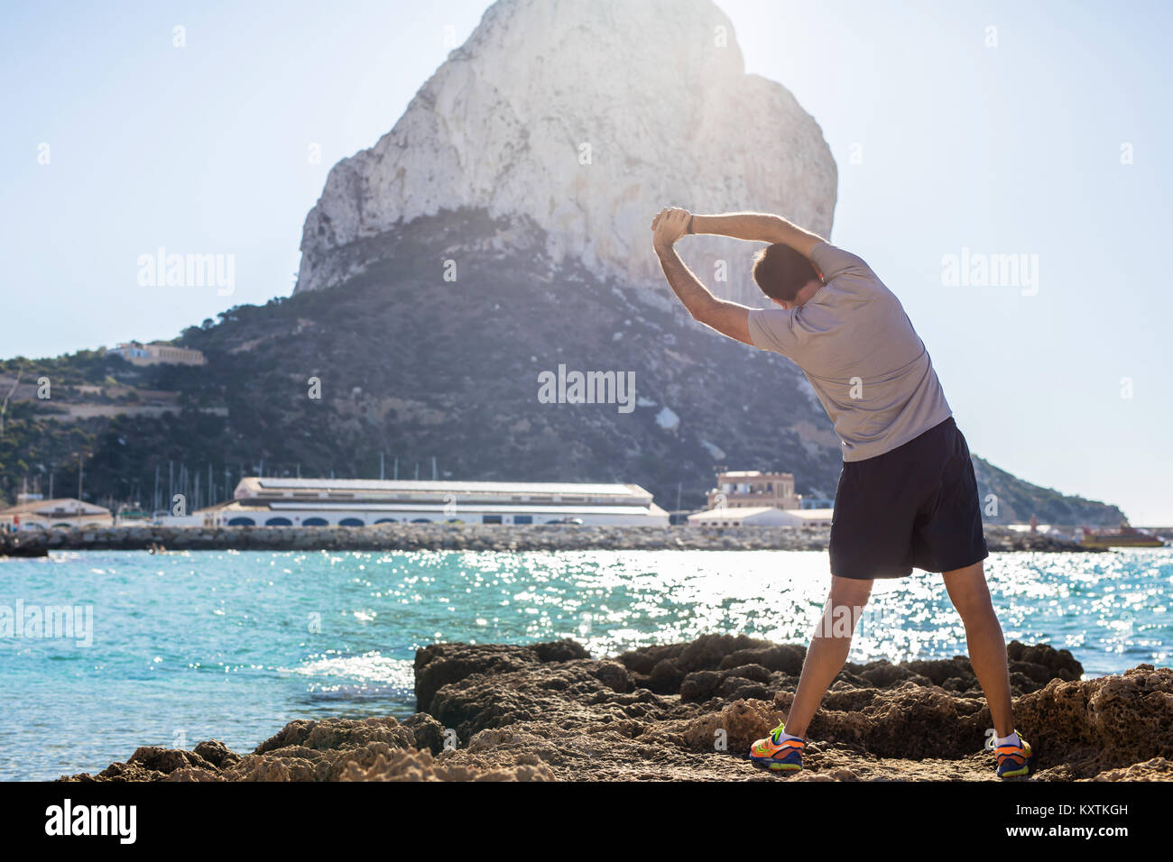 Man warming up at ocean Stock Photo