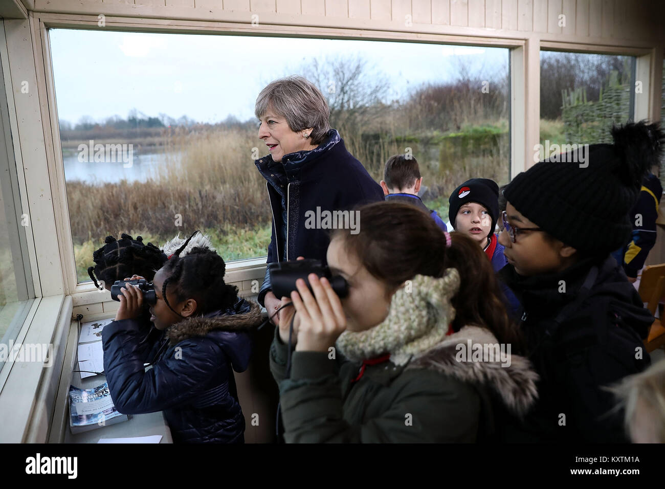 Prime Minister Theresa May stands with school children inside a bird hide at the London Wetland Centre in South West London, where she set out her vision for protecting the environment. Stock Photo