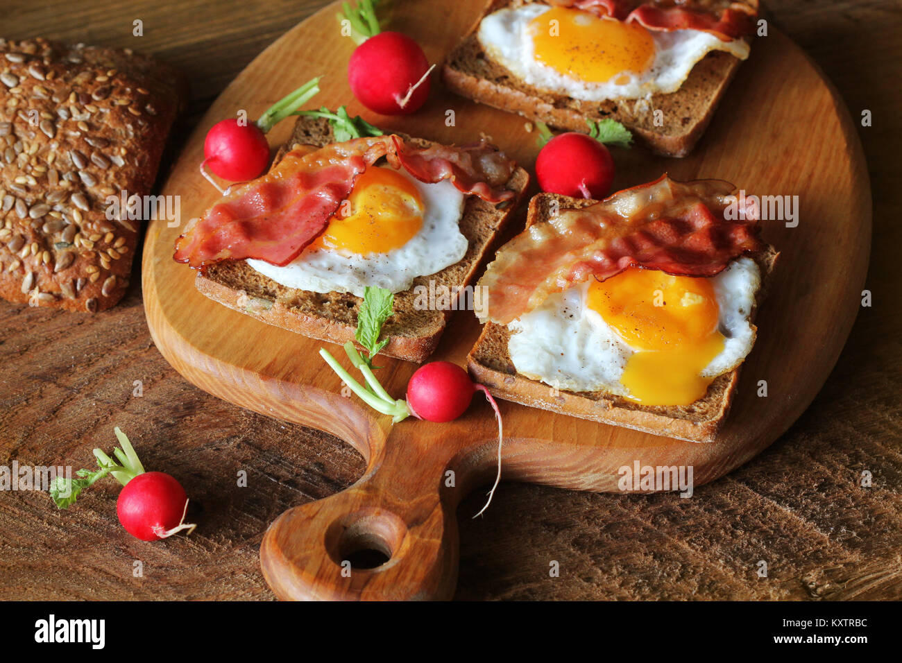 Breakfast , crispy bacon, fried eggs and bread. Sandwiches on cutting