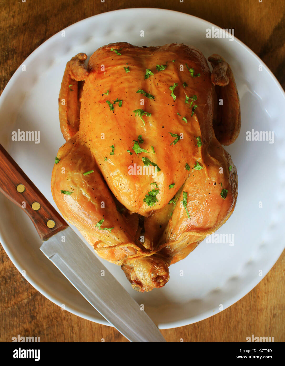 Whole roasted chicken with herb on white plate Stock Photo