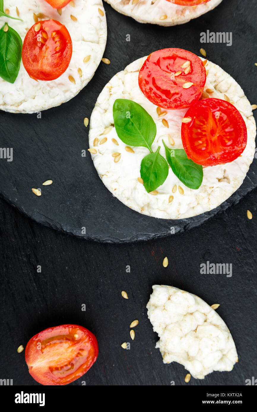 Healthy Rice Cakes with cherry tomatoes, cheese feta, basil and sesame