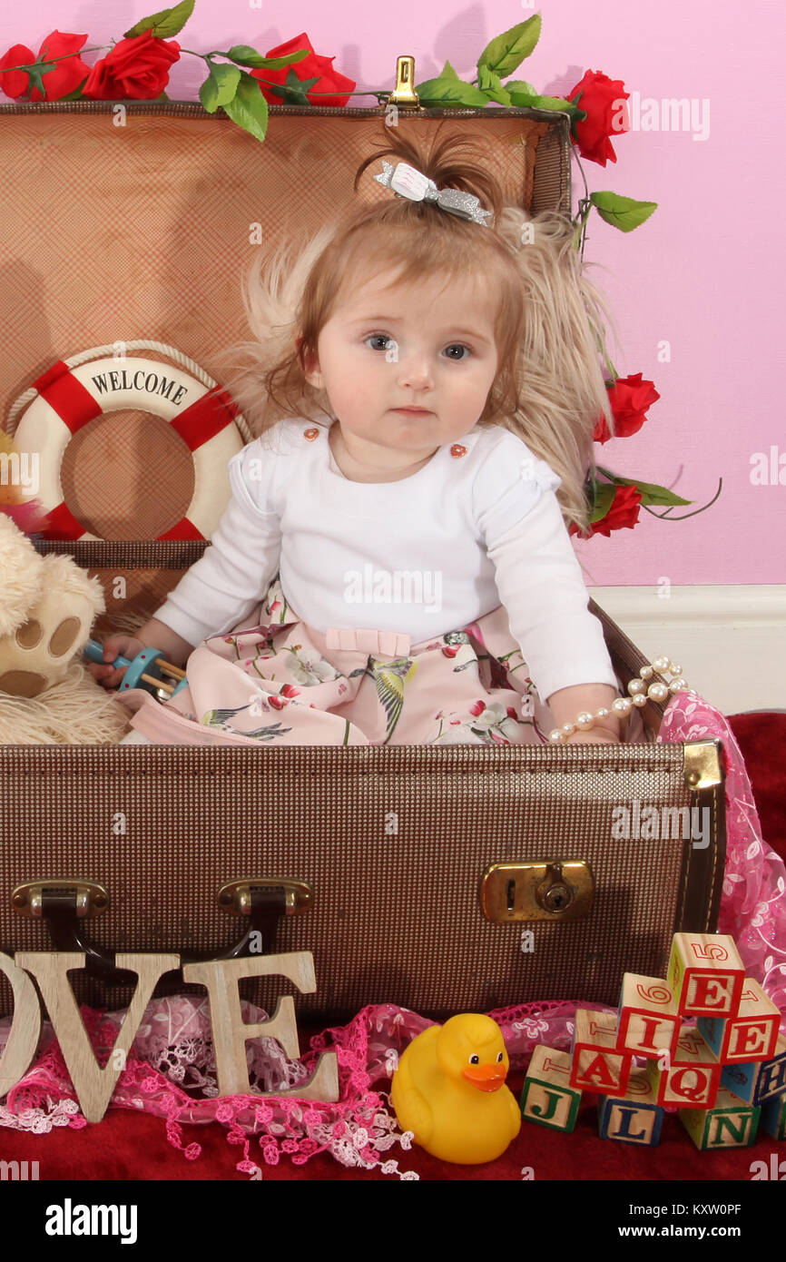 baby girl playing in vintage suitcase, toys, play time Stock Photo