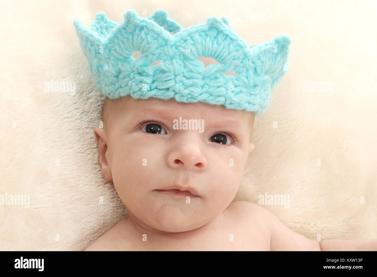 baby boy playing on soft rug, blue crown Stock Photo Alamy