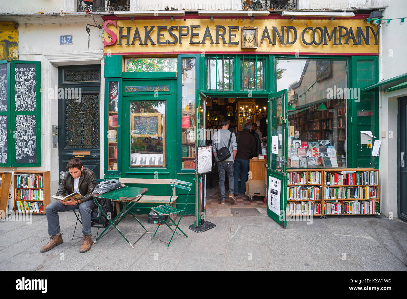 Paris Shakespeare And Company, a young man reads a book outside the famous  Shakespeare And Company bookshop in the Left Bank of Paris, France Stock  Photo - Alamy