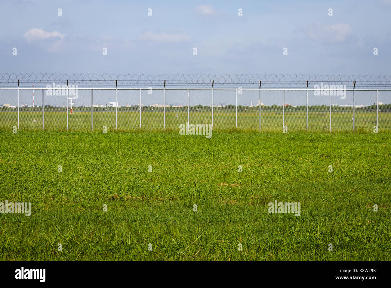 green field and barbed wire fence in jail or security zone Stock Photo