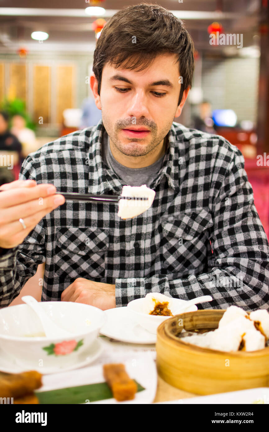 Foreigner enjoying Chinese food in restaurant Stock Photo