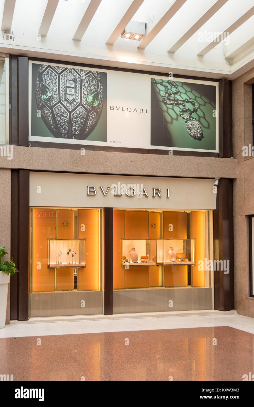 The  Bvlgari or Bulgari jewelery shop in glossy, glass-roofed shopping center full of upmarket designer fashion stores. Stock Photo