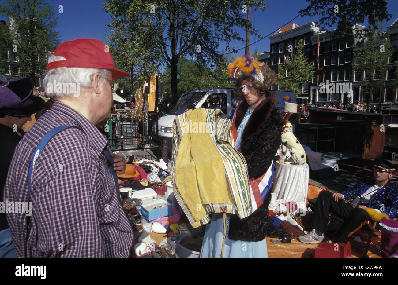 The Netherlands. Amsterdam. Annual festival on 27 april called Koningsdag (Kingsday), celebrating the king's birthday. Transvestite selling clothes to Stock Photo