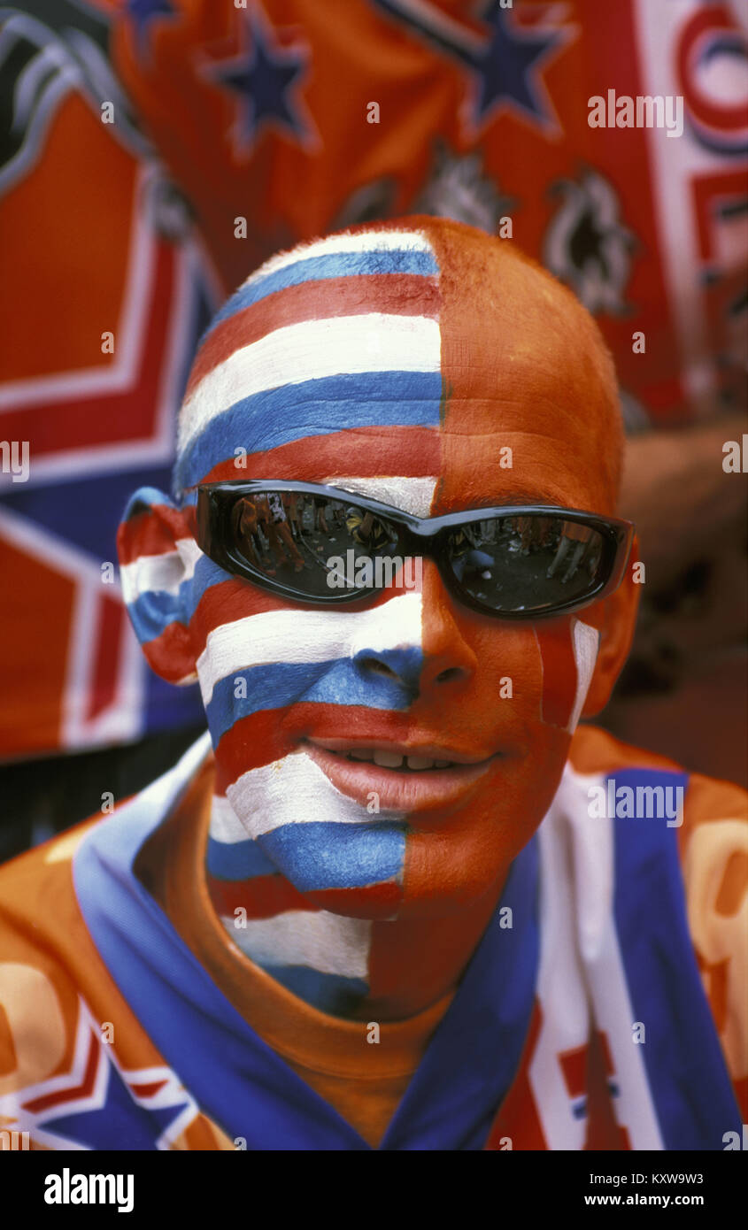 The Netherlands. Amsterdam. Supporters of Dutch football team in national colours. Flag (red, white, blue) and national colour (orange). Stock Photo
