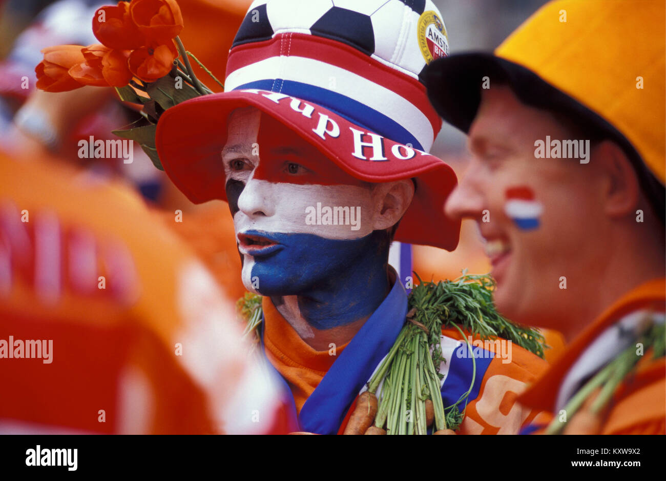 The Netherlands. Amsterdam. Supporters of Dutch football team in national colours. Flag (red, white, blue) and national colour (orange). Stock Photo