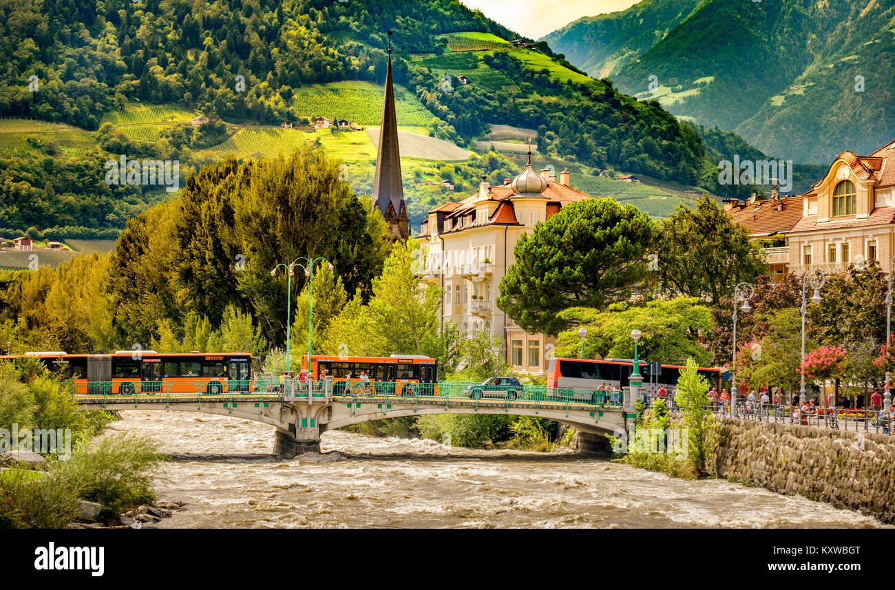 Merano Bolzano buses on bridge over river in mountain village Stock Photo