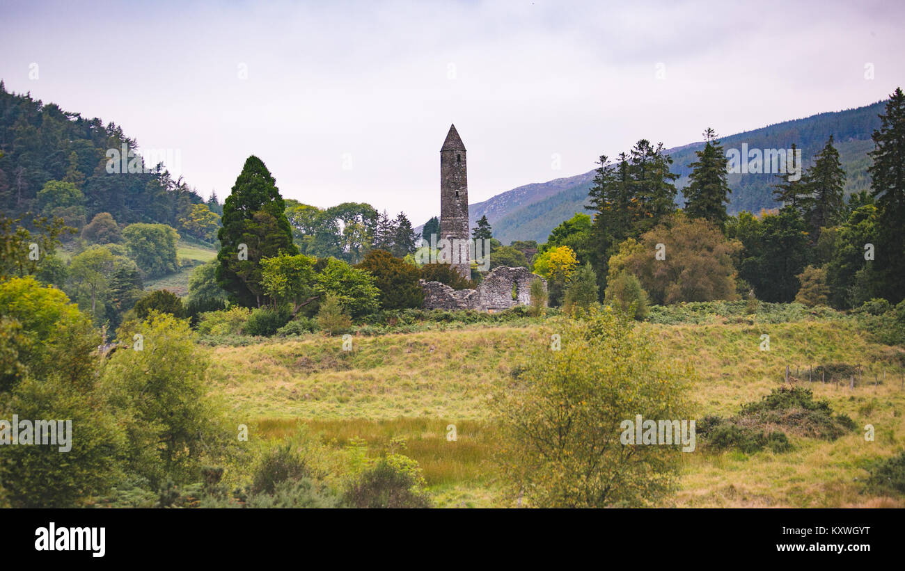 Scenic Glendalough Valley with the round tower and ruins of medieval monastic settlement founded in the 6th century by St Kevin Stock Photo