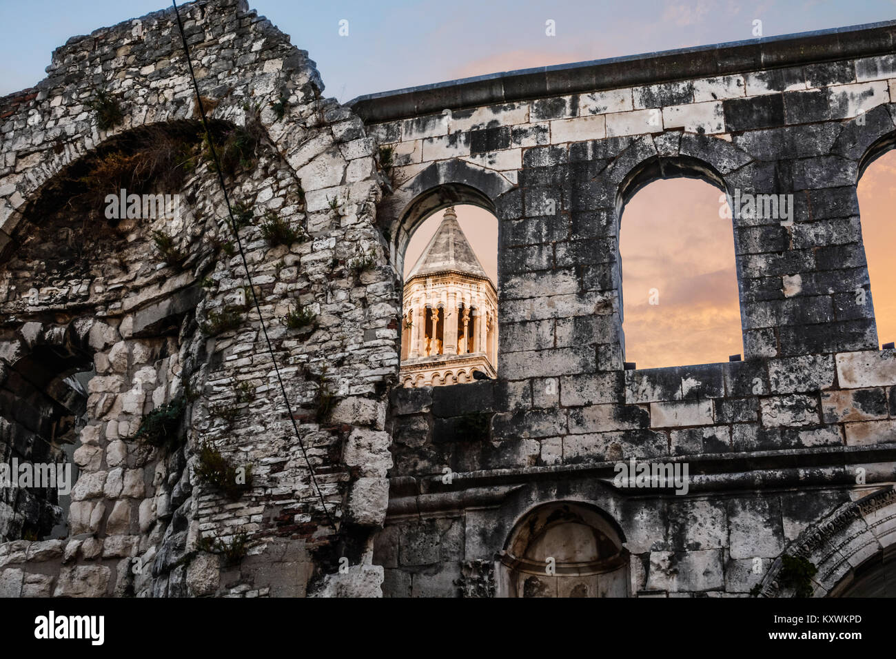 Silver Gate at the Palace of the Emperor Diocletian in Split Croatia as the sun sets and light hits the tower of Cathedral Saint Domnius Stock Photo