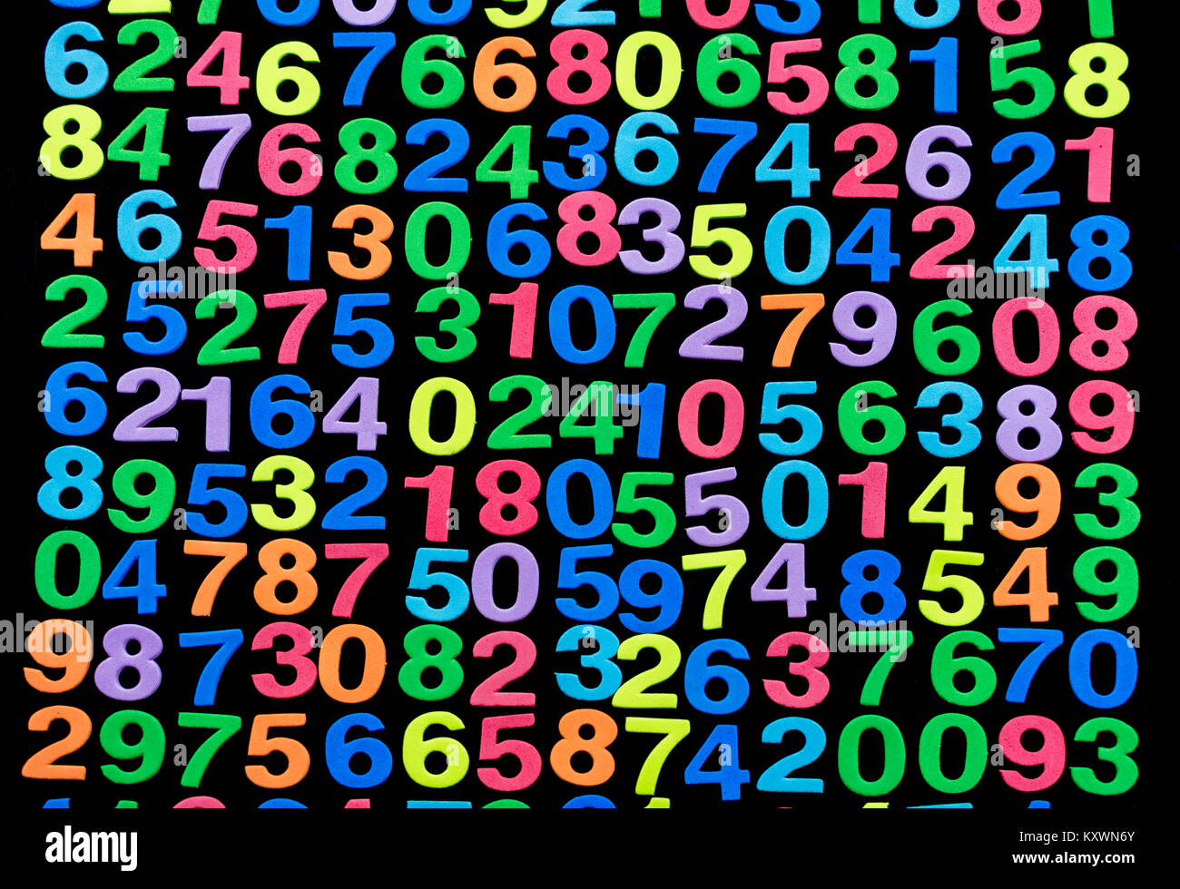 Multiple rows and columns of foam cut colored numbers in random order , against a black background Stock Photo