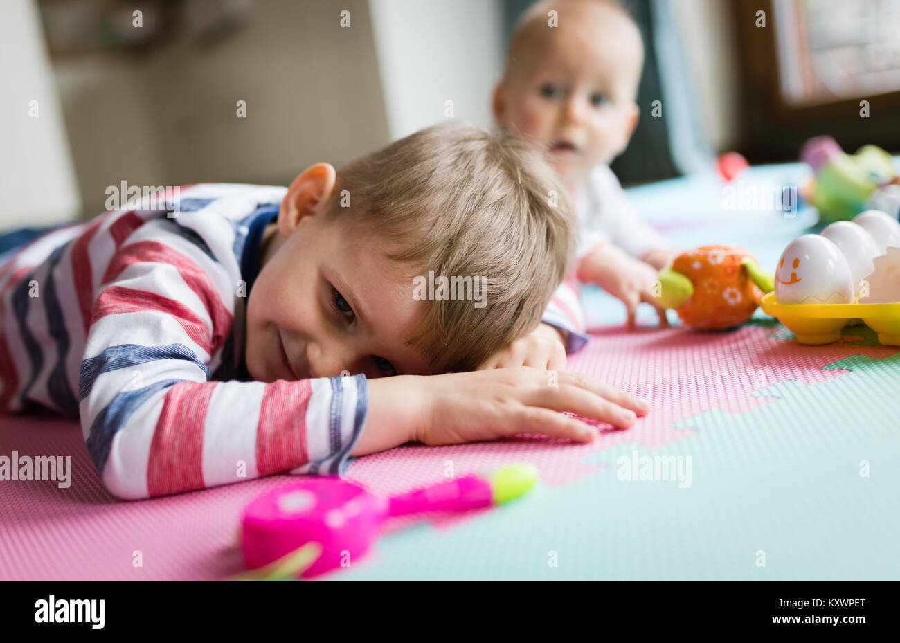 Cute little children playing while sitting on carpet Stock Photo