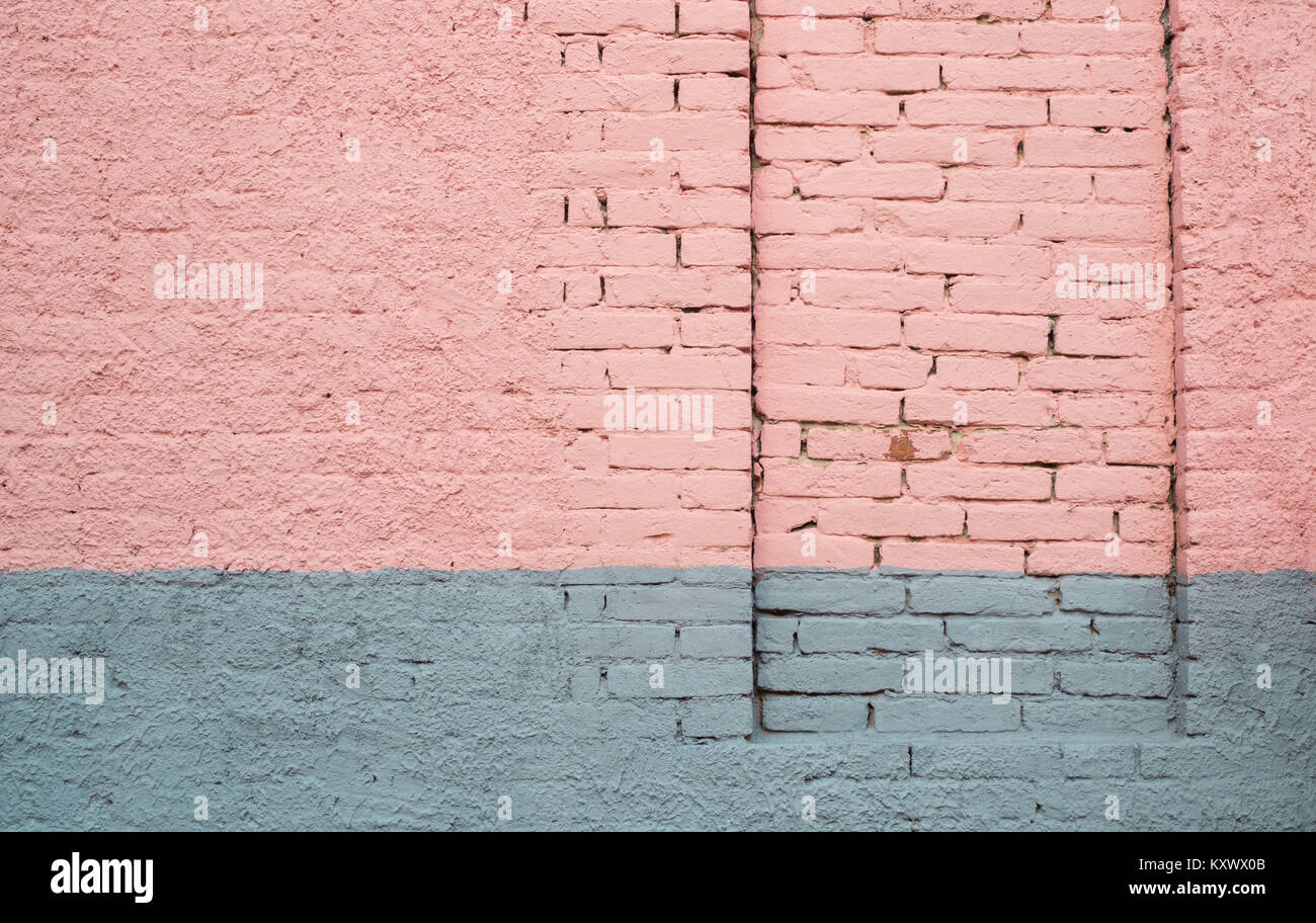 Pink and gray painted brick wall with a permanently closed door Stock Photo