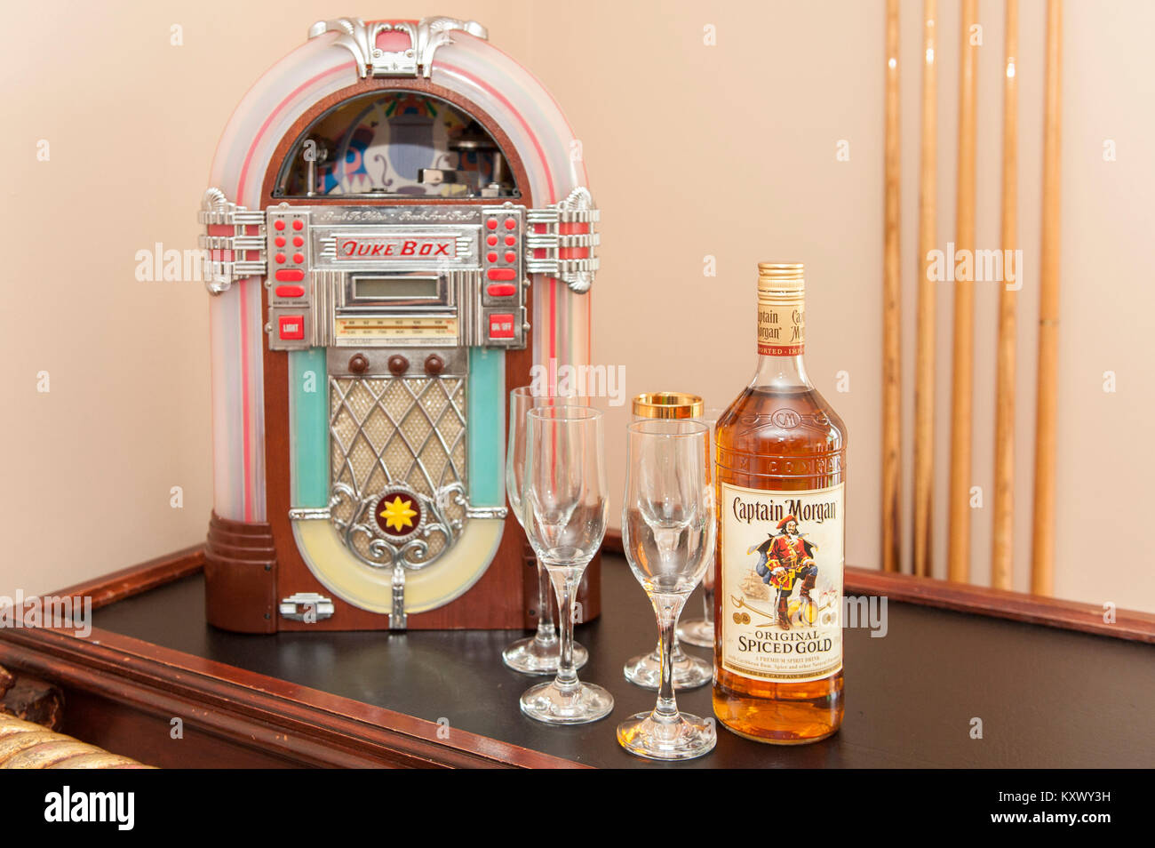 Bottle of Captain Morgan Rum with 5 glasses and a mini juke box with copy space. Stock Photo