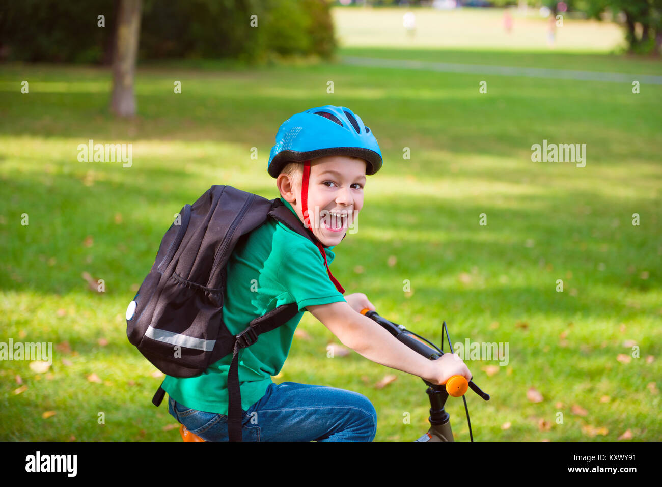 Happy little boy cycling in summer park Stock Photo