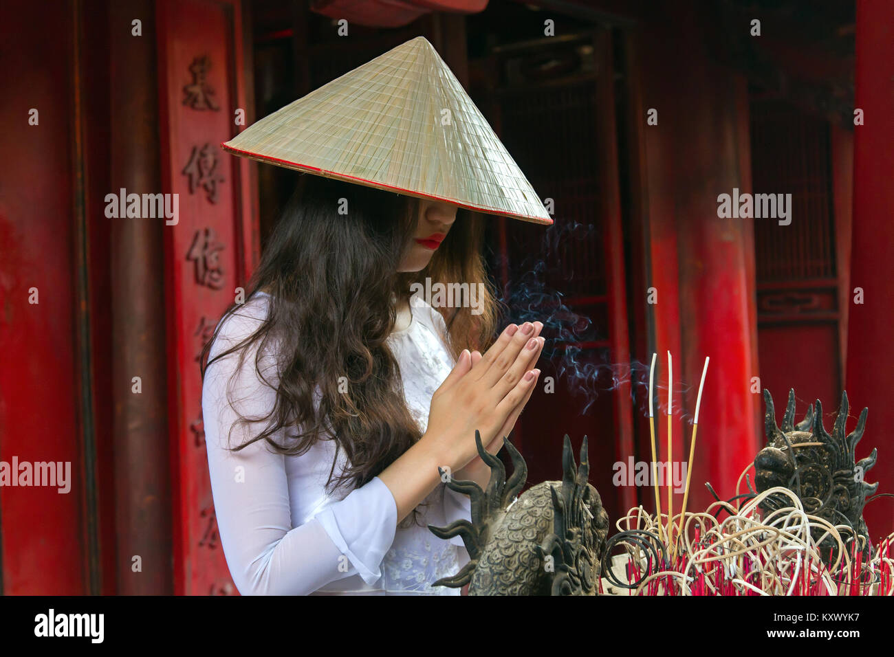 Young Vietnamese woman in Temple of Literature, Hanoi, Vietnam. She is wearing the traditional Ao Dai dress. Stock Photo