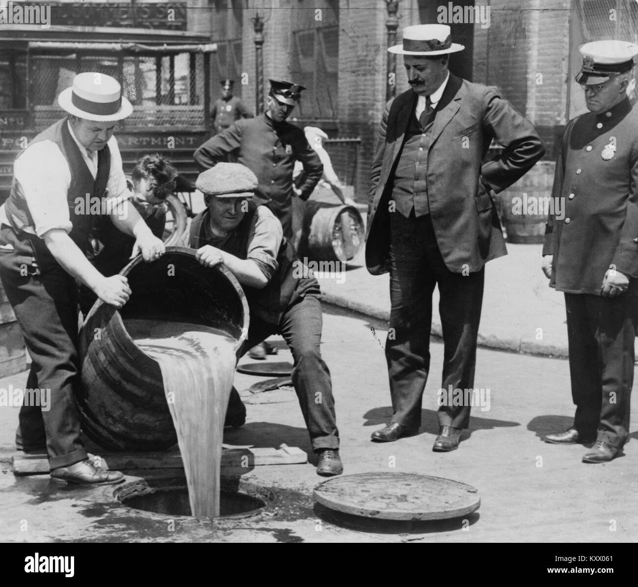 Pouring out illegal alcohol into a Sewer Stock Photo