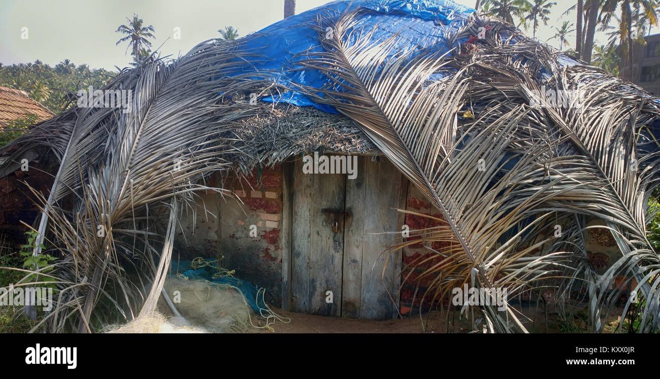 Fishing half dugout (pandal) covered with palm leaves on shores of Arabian sea, fishing nets are on verge of. Kerala Stock Photo