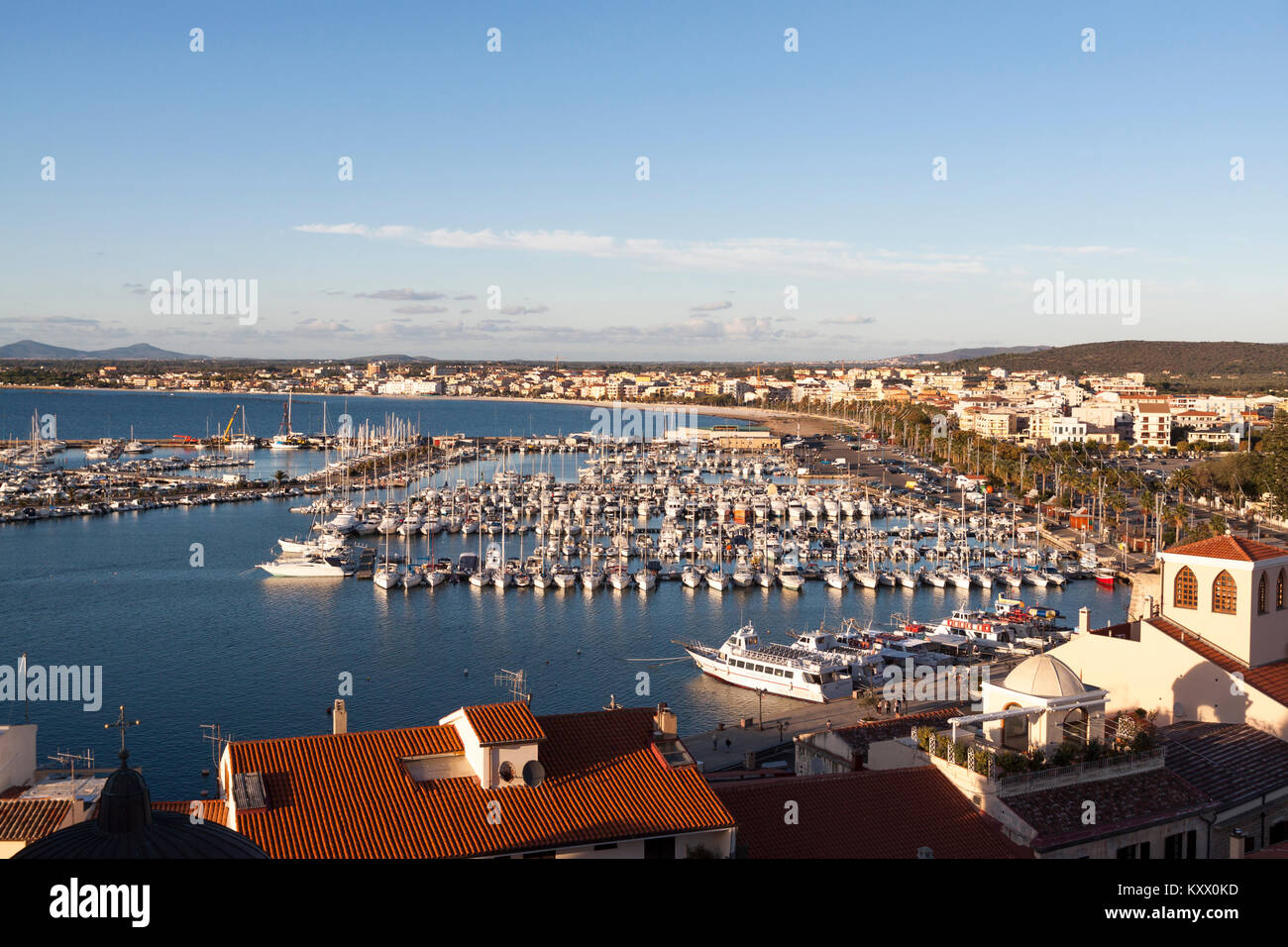 Aerial view of city against romantic skyline at sunset. Alghero ...