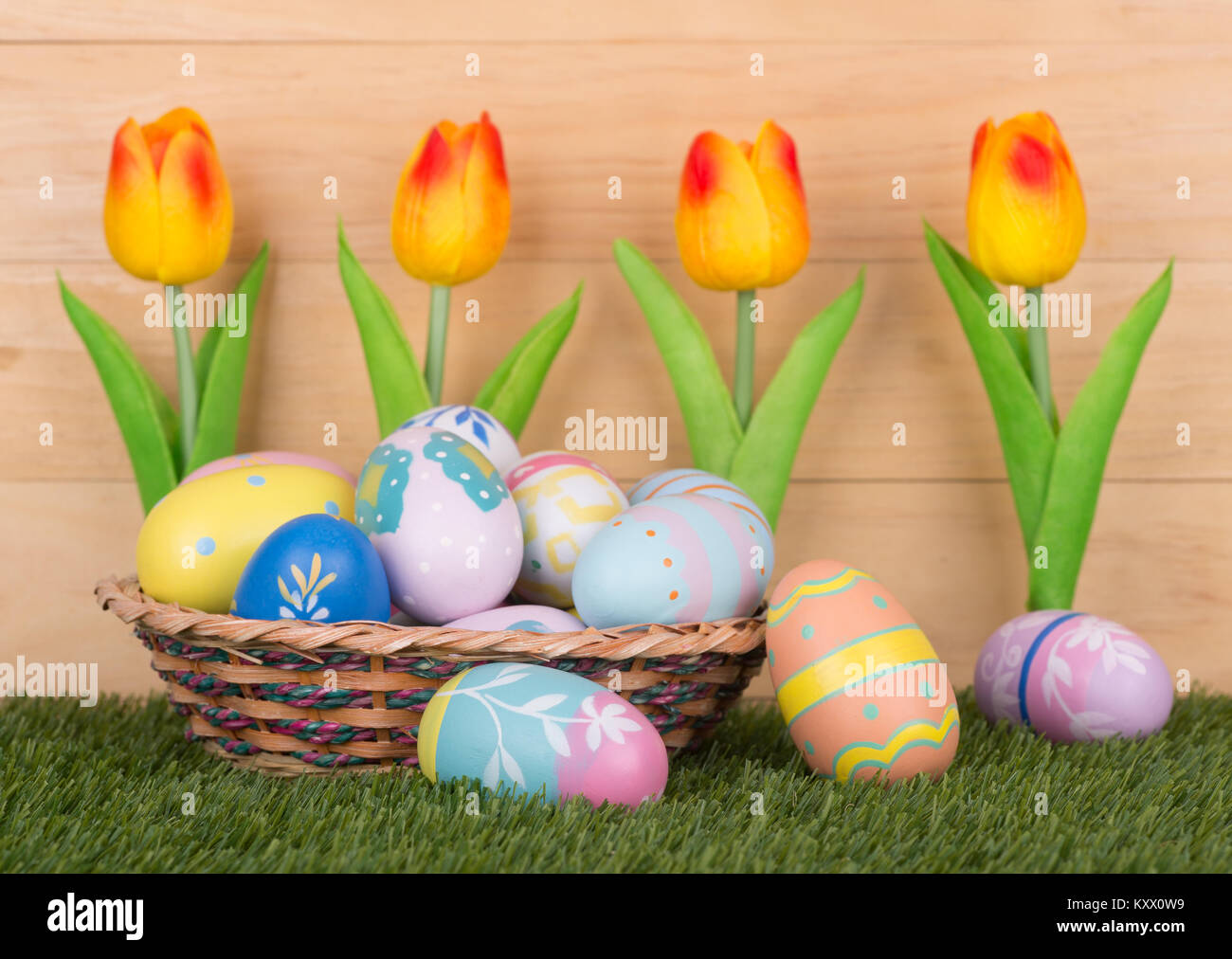 Colorful Easter eggs and tulips against a wood background Stock Photo ...