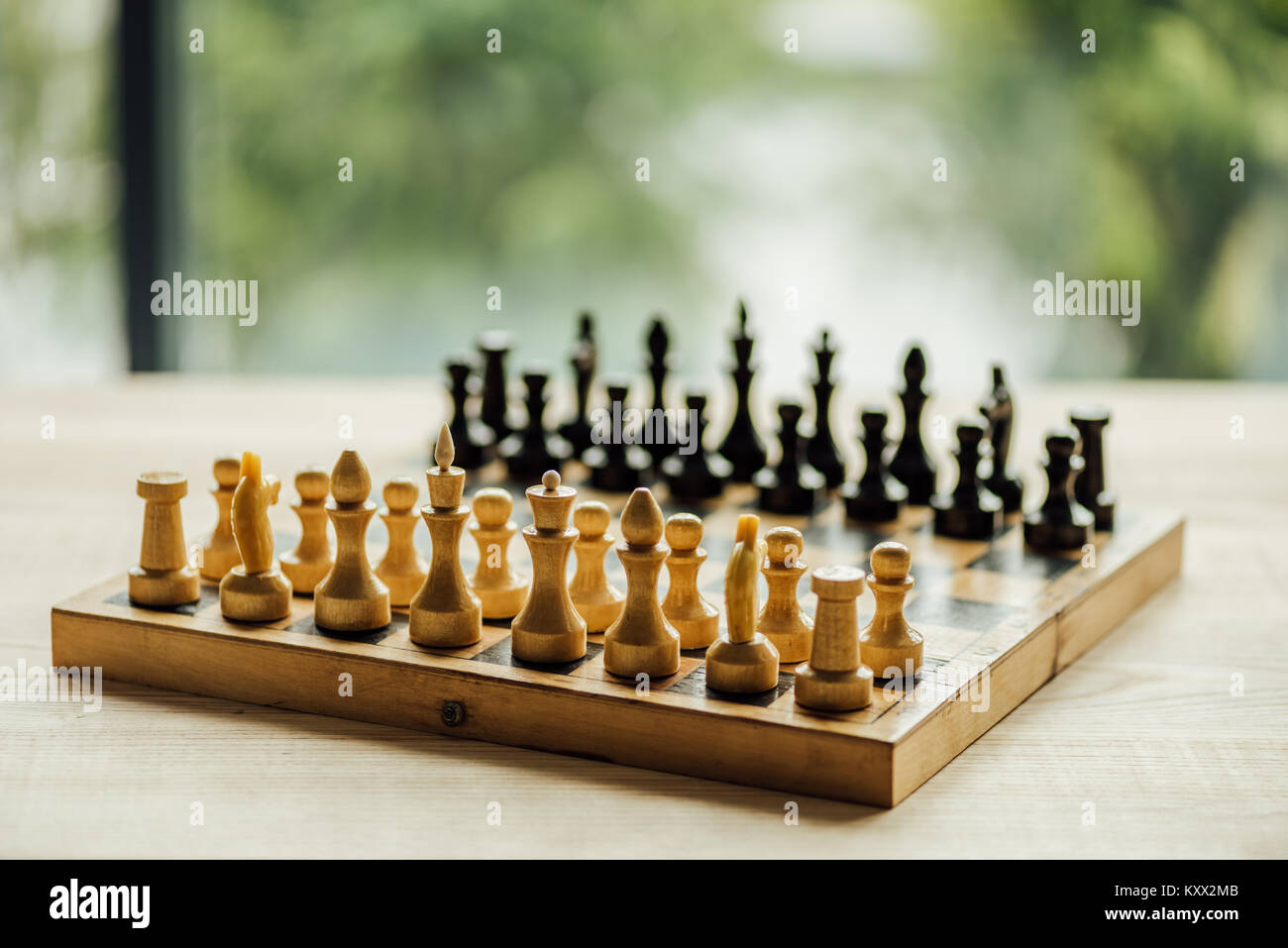Old chess board set for a new game on the table. Selective focus on white chess figures  Stock Photo