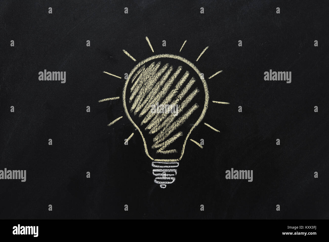 close up of yellow electric bulb drawn on black chalkboard Stock Photo