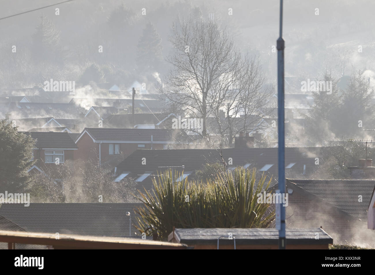 fog clearing and buildings drying out under the sun on a foggy day in the uk Stock Photo