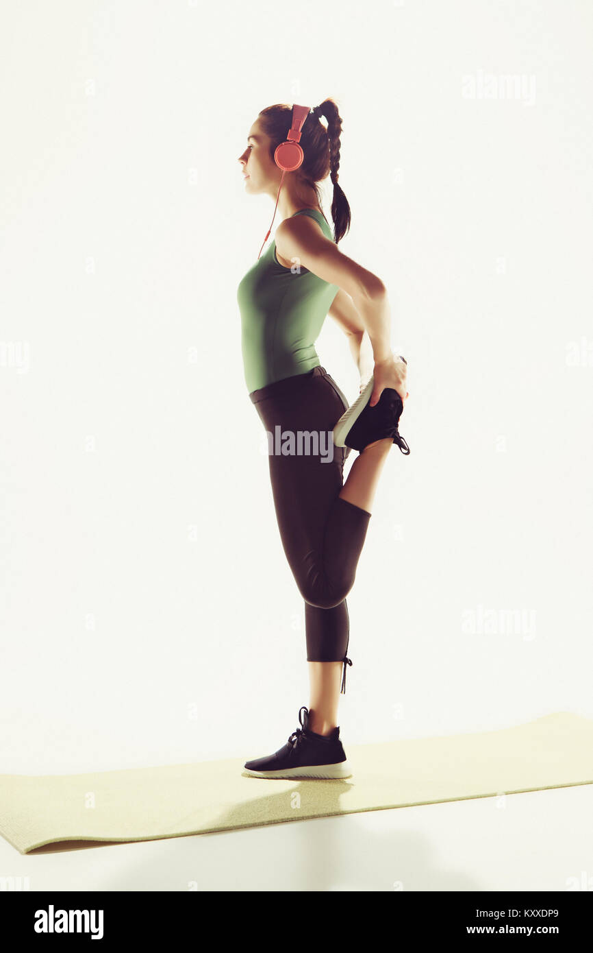 The side view of a young woman stretching body in gymnastics class ...
