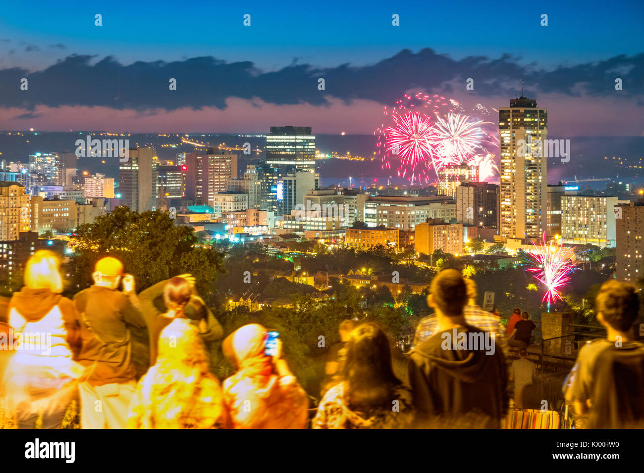 People enjoy fireworks above the skyline of Hamilton Ontario Canada during the Canada Day celebrations. Stock Photo