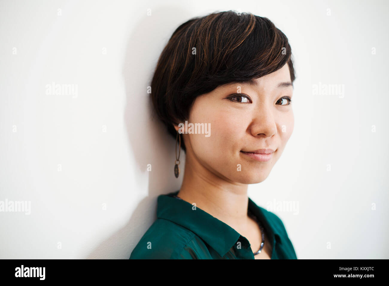Woman With Short Black Hair Wearing Green Shirt Standing In