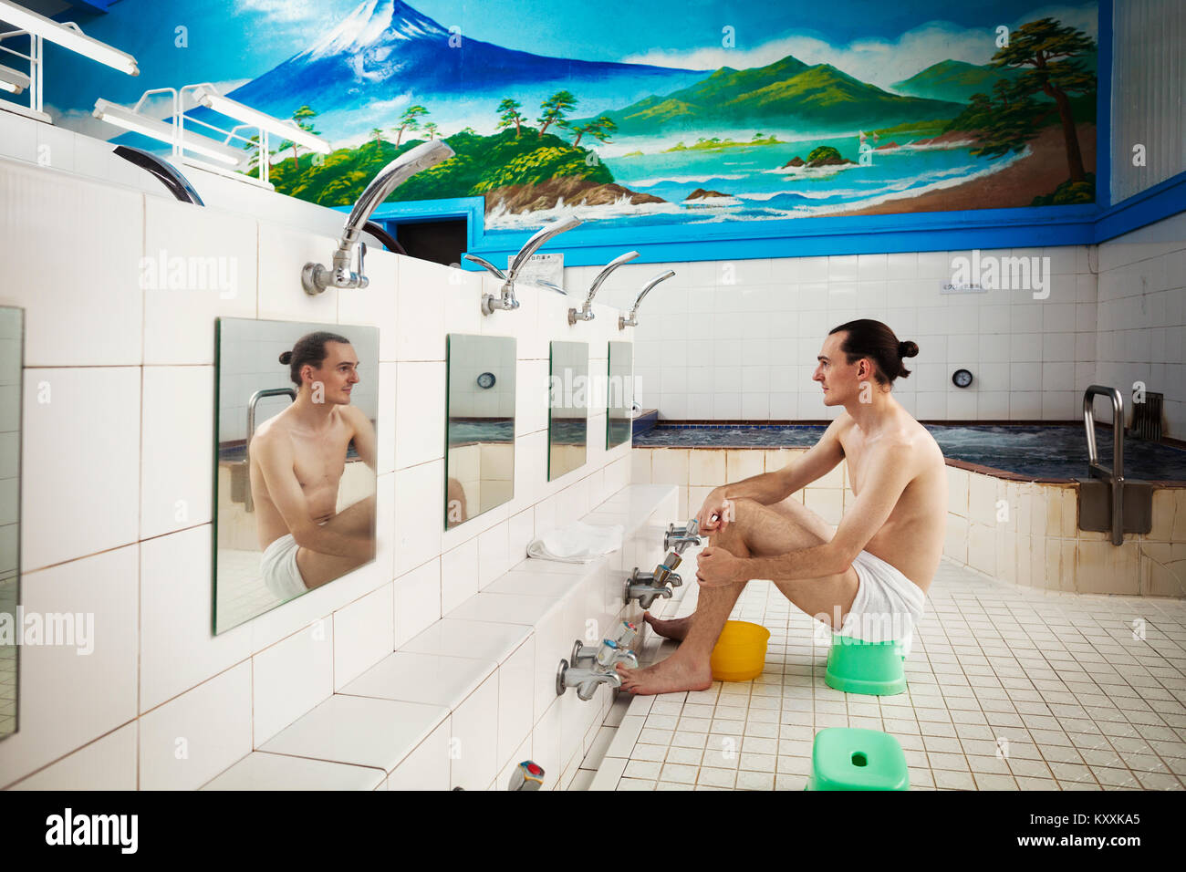 public shower boys A young Western man seated in a towel, at the shower area, showering before  he enters the public bath Stock Photo - Alamy