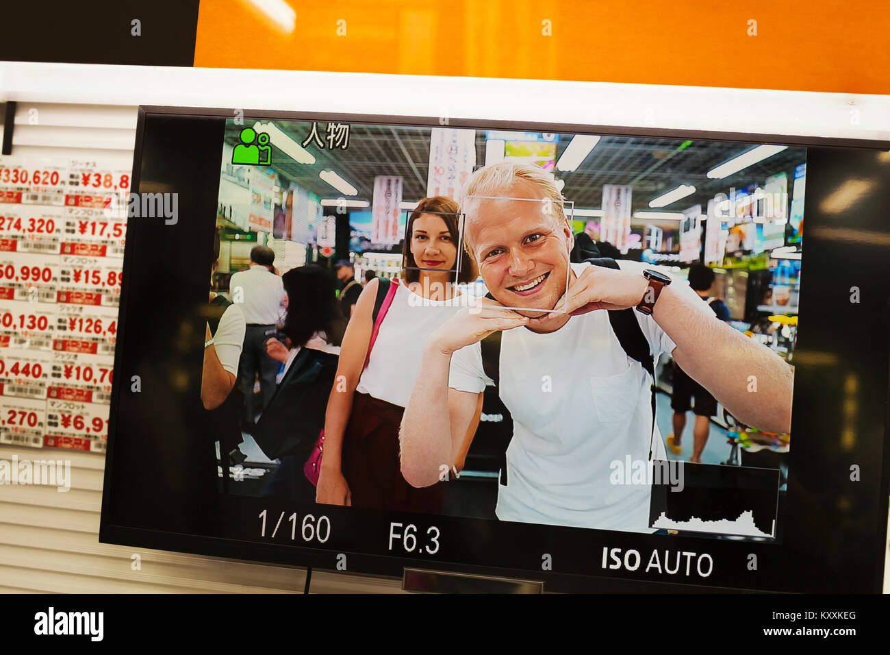 Close up of picture on smartphone showing smiling man and woman looking at camera. Stock Photo