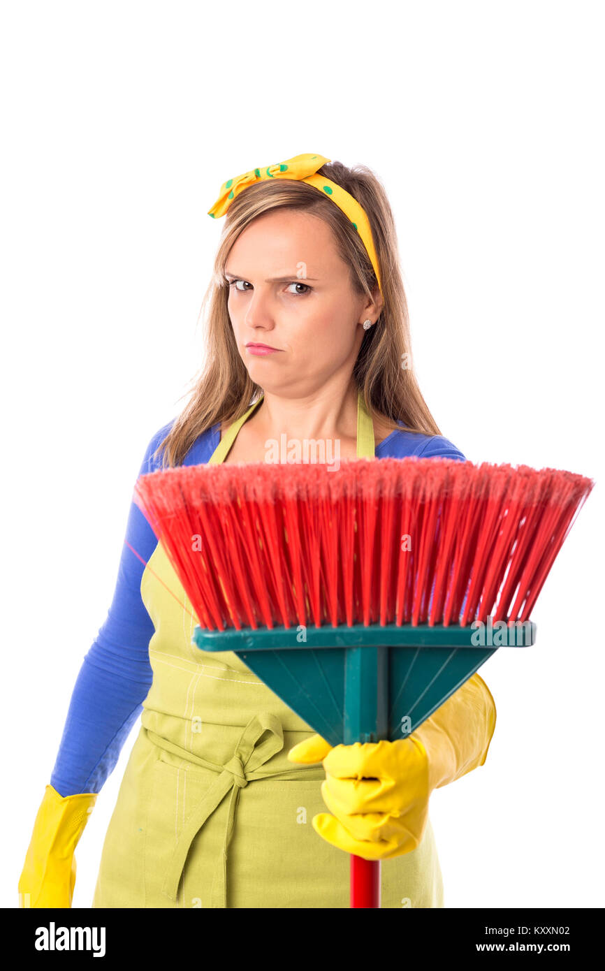 Young sad housewife with yellow rubber gloves holding a broom over white background Stock Photo