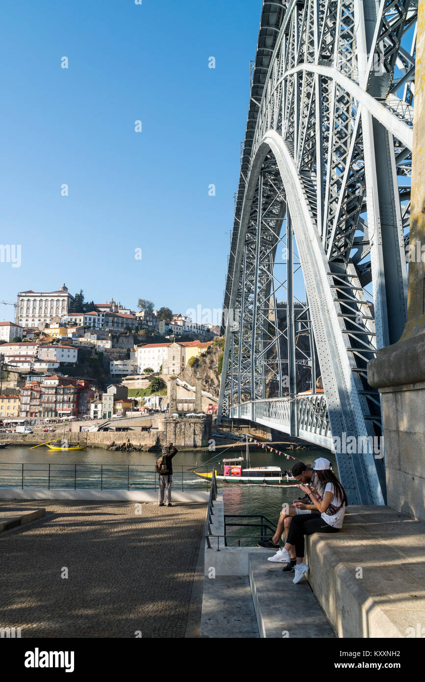 the River Douro waterfront looking towards the Ribeira district of Porto, Portugal. with the Dom Luis I Bridge in the foreground. Stock Photo