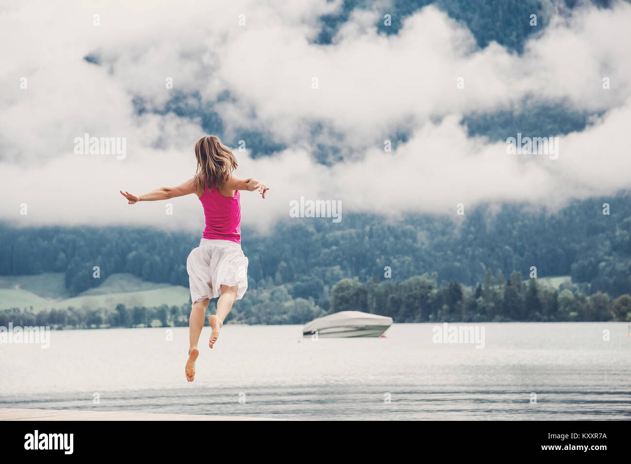 Woman jumping at the lake Stock Photo