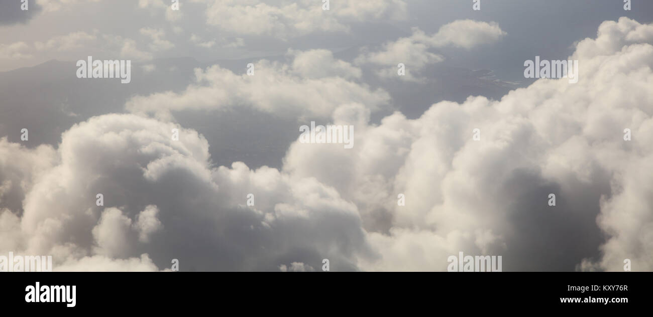 Clouds white and grey on dark blue sky background. Aerial photo from plane's window Stock Photo