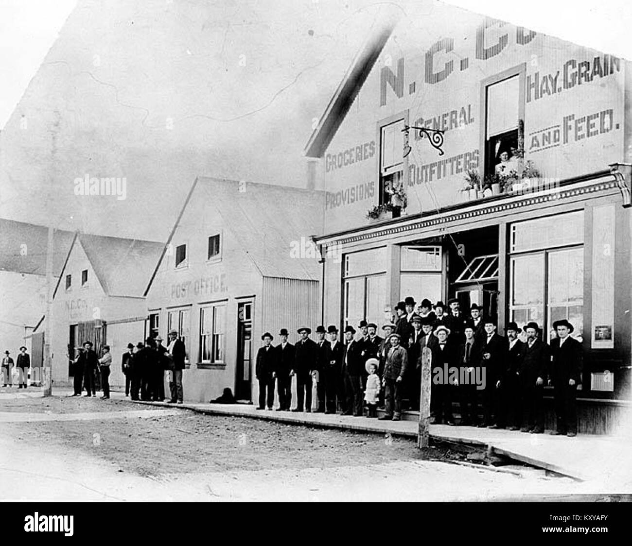 Group of people outside Northern Commercial Company store and a post