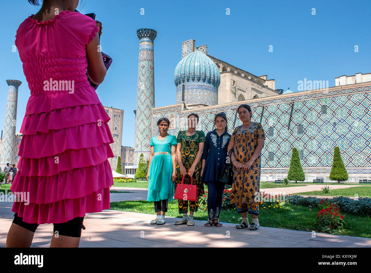 Women take pictures outside the Registan in Samarkand Stock Photo