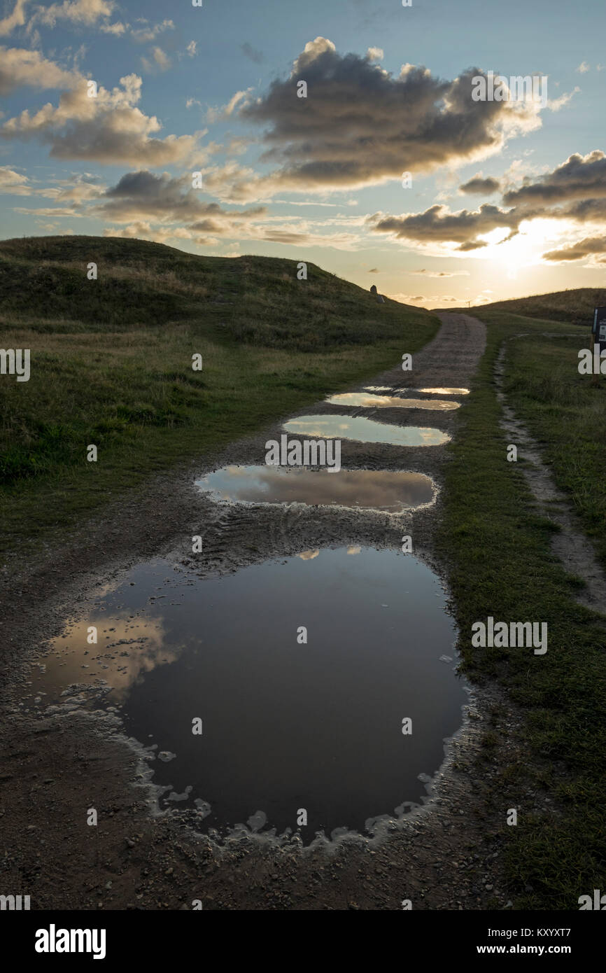 Puddles on a dirt road, dunes, clouds, sun Stock Photo