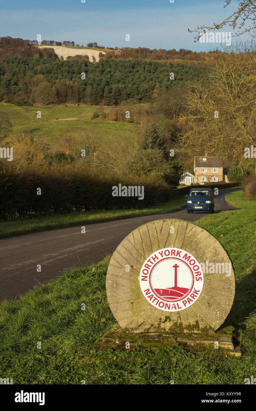 Car driving near boundary stone at entrance to North York Moors