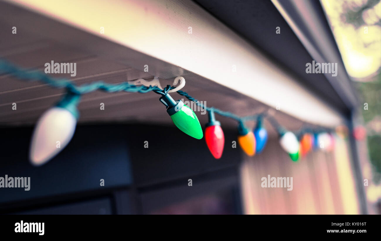 Colorful Christmas Lights Hanging From The Roof Of A House